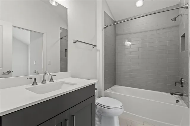 a bathroom with a sink a toilet a mirror a bathtub and shower