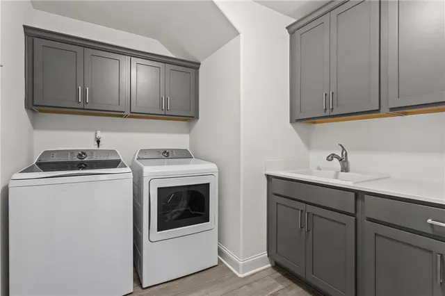 a utility room with sink dryer and washer