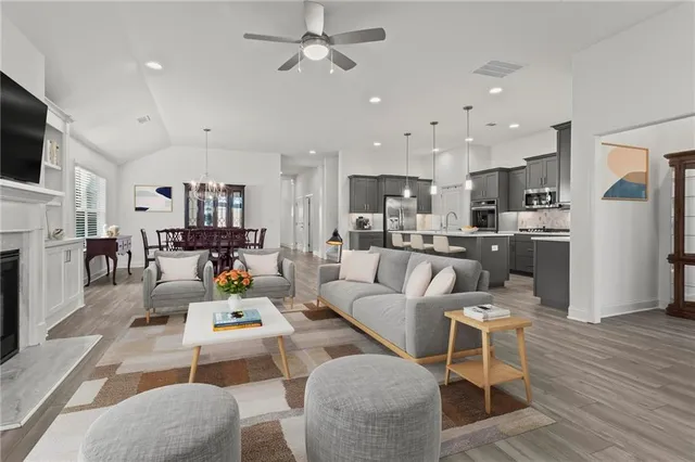 a living room with furniture a kitchen view and a fireplace