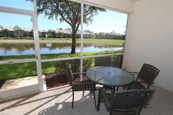 a view of a chairs and table in the patio next to a yard