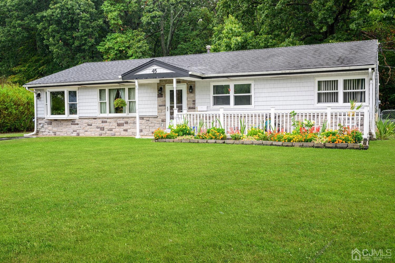 45 Stockton Road Kendall Park, NJ 08824 - Photo 2 of 30 a front view of a house with a garden and trees