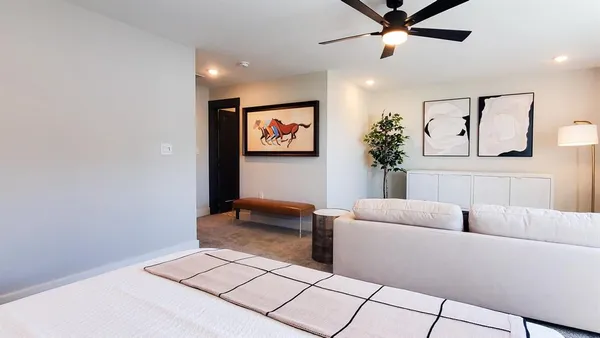 a living room with furniture and a ceiling fan