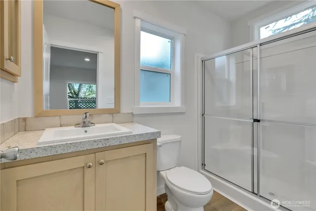 a bathroom with a granite countertop sink toilet and shower