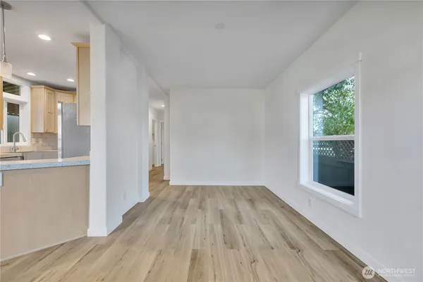 a view of a hallway with wooden floor and a living room