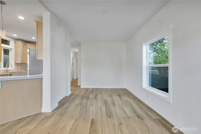 a view of a hallway with wooden floor and a living room