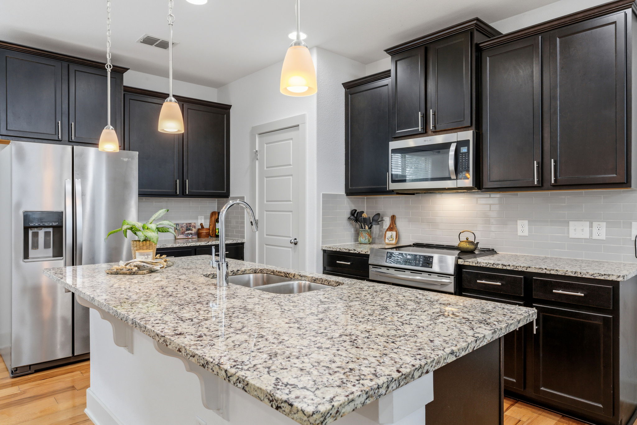 1007 Totis Road Austin, TX 78748 - Photo 13 of 37 a kitchen with kitchen island granite countertop wooden cabinets appliances and granite counter tops