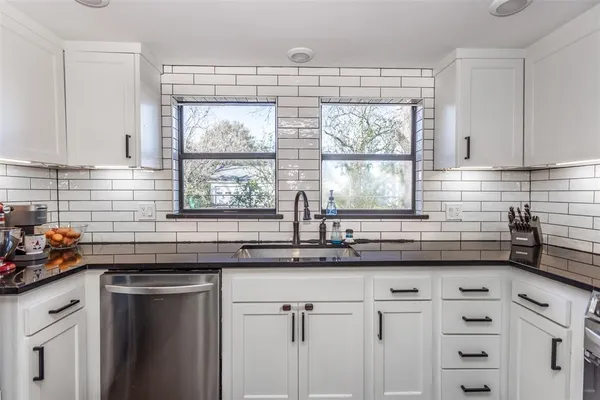 a kitchen with a sink a window and cabinets