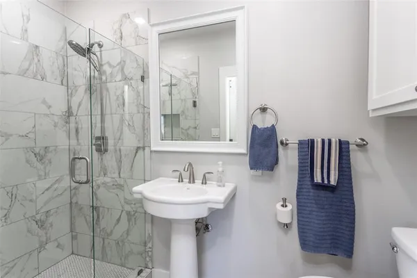 a bathroom with a sink shower and a mirror