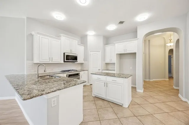 a kitchen with stainless steel appliances granite countertop a stove sink and cabinets