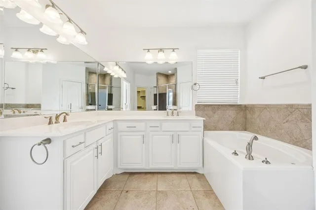a spacious bathroom with a tub sink and mirror