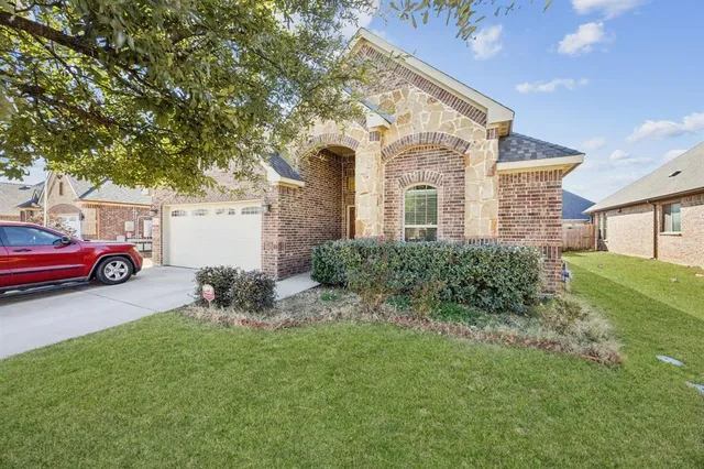 a front view of a house with a garden and trees