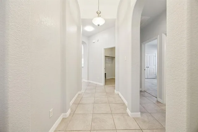 a view of a hallway with wooden floor and a bathroom