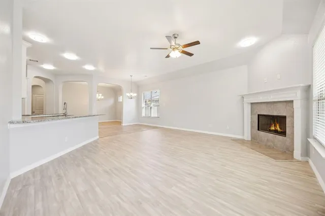 a view of an empty room with a fireplace and a window