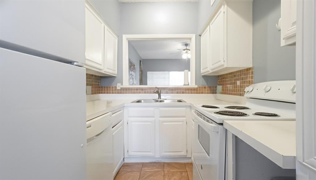 12921 Abrams Road, Unit 505 Dallas, TX 75243 - Photo 5 of 24 Kitchen with white appliances, white cabinetry, light countertops, light tile patterned floors, and ceiling fan