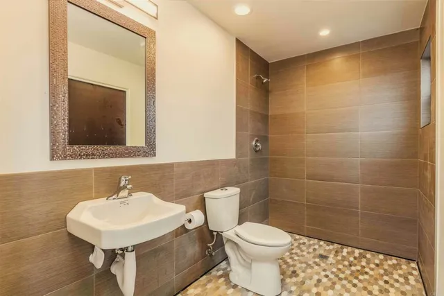 a bathroom with a sink a toilet and a mirror