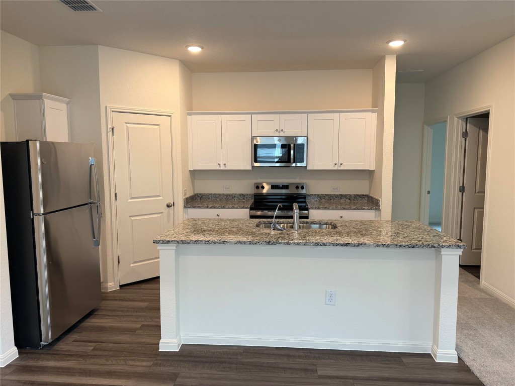 417 Wedemeyer Street Taylor, TX 76574 - Photo 5 of 15 a kitchen with stainless steel appliances granite countertop a refrigerator a stove and a sink
