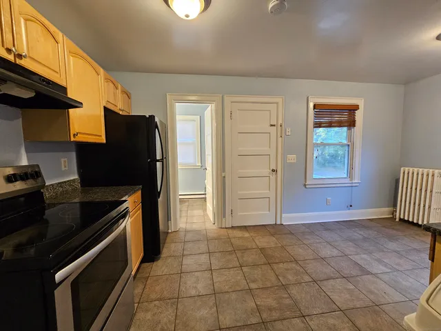 a kitchen with granite countertop a refrigerator and a stove top oven