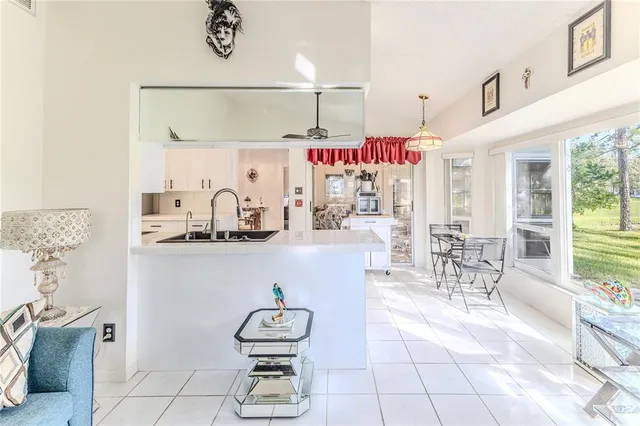 a view of kitchen with refrigerator and white cabinets