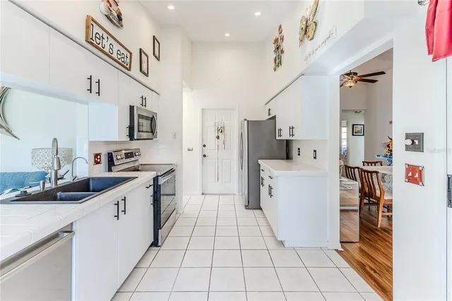 a kitchen with stainless steel appliances granite countertop a sink a stove a microwave cabinets and a dining table