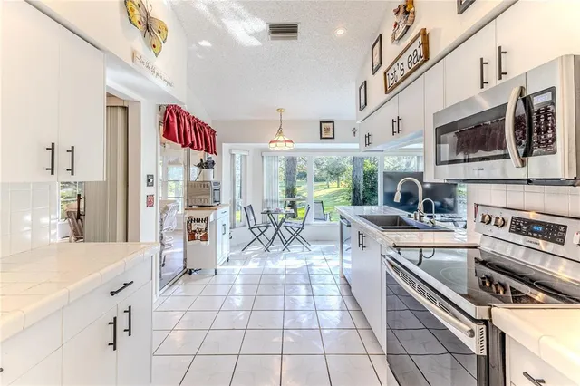 a bedroom with a bed a chair and a chandelier