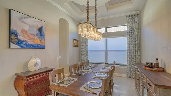 a living room with furniture kitchen view and a chandelier