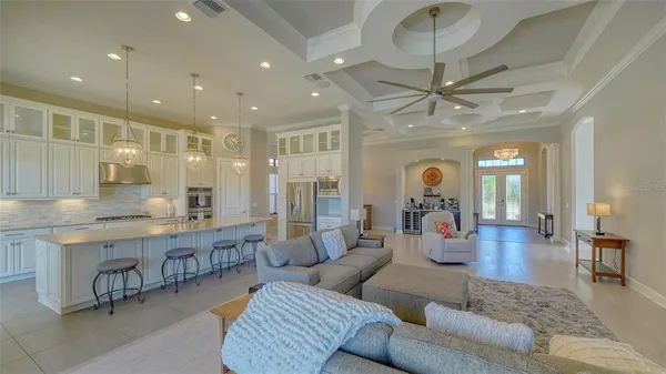 a living room with furniture a flat screen tv and floor to ceiling window