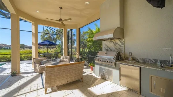 a living room with patio furniture and floor to ceiling window