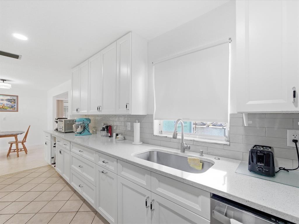 4069 Gulfview Drive Hernando Beach, FL 34607 - Photo 19 of 29 a kitchen with stainless steel appliances a sink a stove and white cabinets