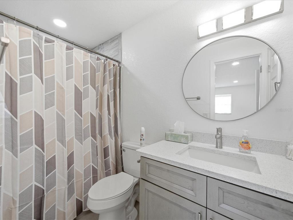 4069 Gulfview Drive Hernando Beach, FL 34607 - Photo 23 of 29 a bathroom with a granite countertop sink a toilet and a mirror