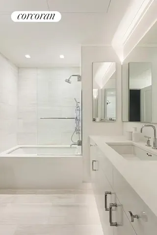 a bathroom with a tub a sink and mirror