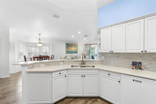 a kitchen with granite countertop white cabinets and white appliances