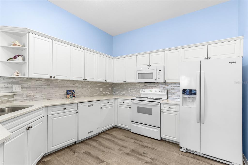 2031 Matecumbe Key Road Punta Gorda, FL 33955 - Photo 12 of 49 a kitchen with granite countertop white cabinets and white appliances