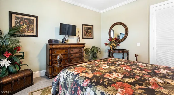 a bedroom with a bed and a potted plant on dresser