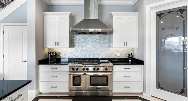 a large white kitchen with stainless steel appliances and a sink