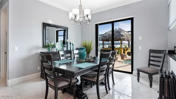 a view of a dining room with furniture a kitchen and chandelier