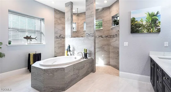 a spacious bathroom with a tub a sink and a mirror