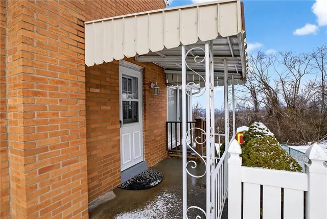 a view of a chair and table in the back yard of the house