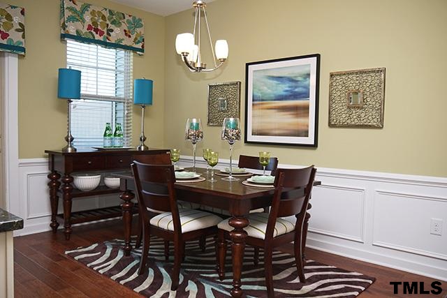 7900 Allscott Way Raleigh, NC 27612 - Photo 3 of 12 a view of a dining room with furniture wooden floor and a chandelier