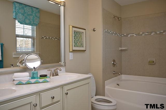 7900 Allscott Way Raleigh, NC 27612 - Photo 5 of 12 a bathroom with a sink a bathtub and a mirror
