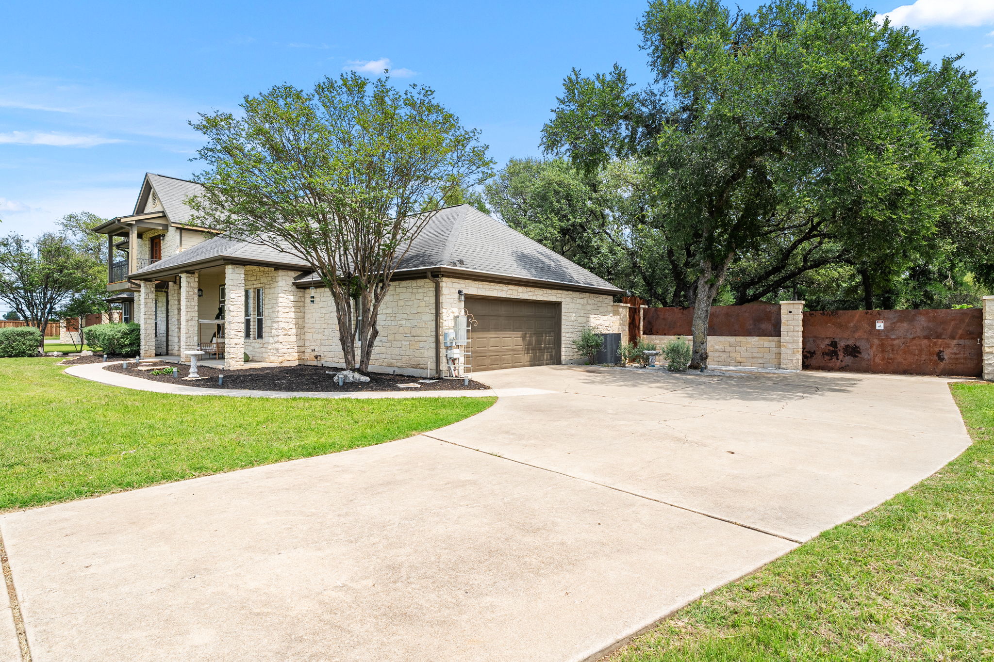 101 Landons Way Georgetown, TX 78633 - Photo 3 of 32 View of the driveway leading to the garage and a gate to get inside the property leading to a car port.
