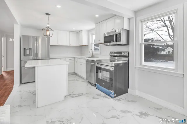 a kitchen with stainless steel appliances granite countertop a stove a sink and a refrigerator