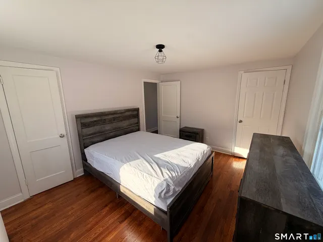 a bedroom with a bed and wooden floor