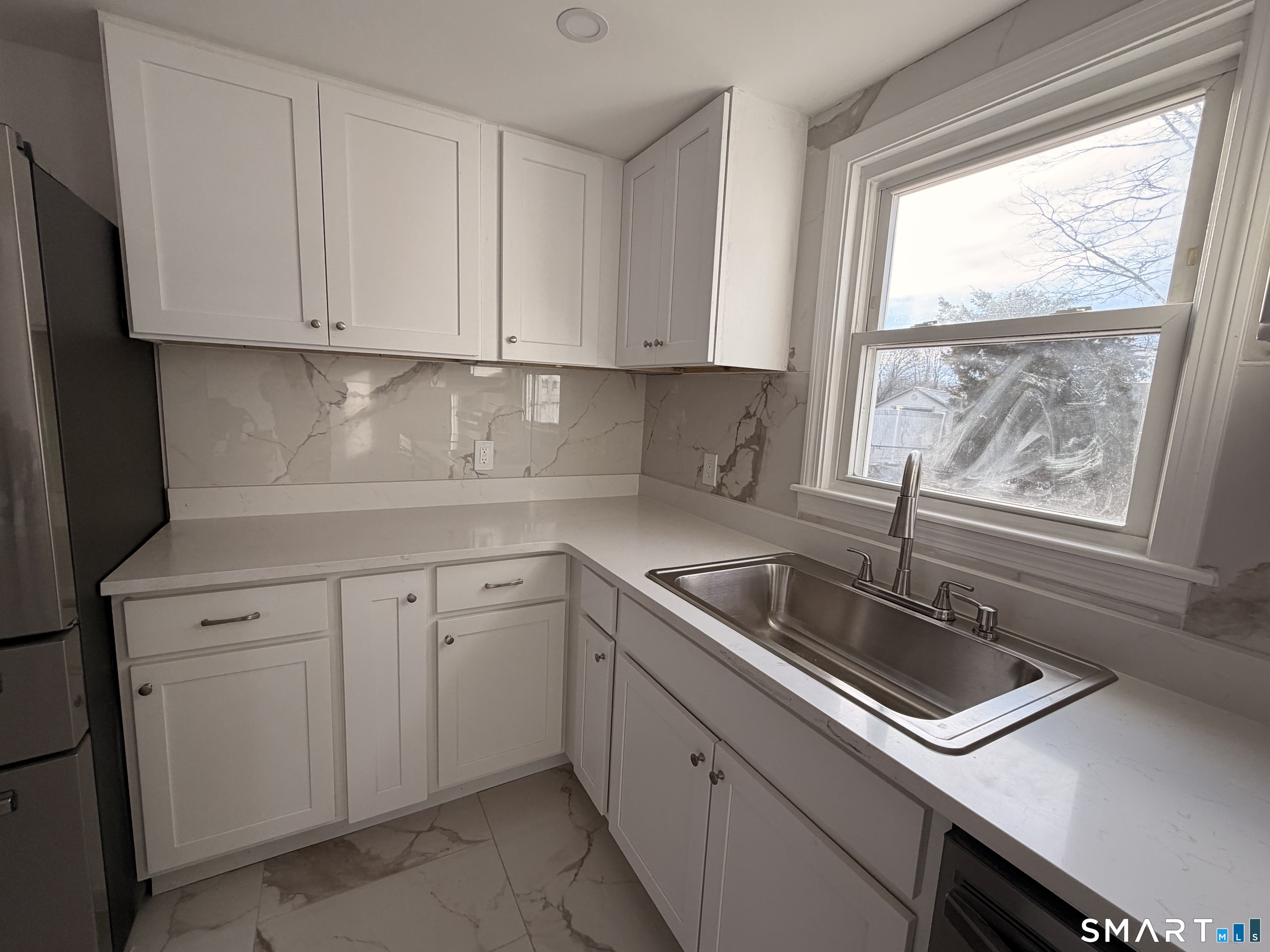 8 River Road East Haven, CT 06512 - Photo 23 of 45 a kitchen with white cabinets appliances a sink and a window