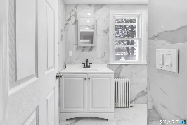 a bathroom with a sink a toilet and a window