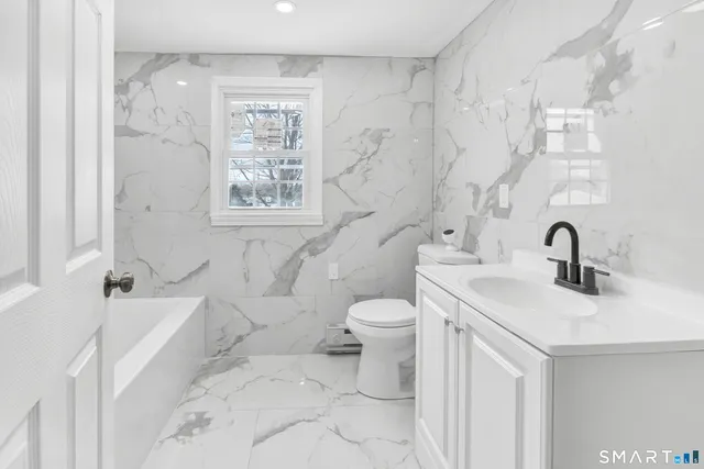 a bathroom with a sink a toilet and a tub