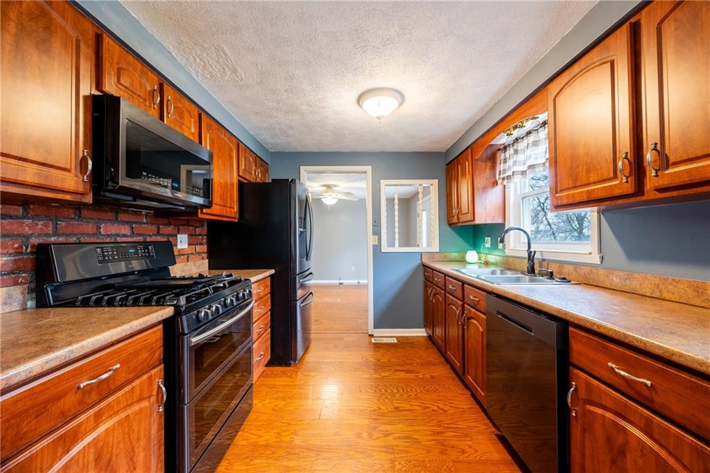 1069 Highfield Road Bethel Park, PA 15102 - Photo 11 of 41 a kitchen with stainless steel appliances granite countertop a stove a sink and a microwave