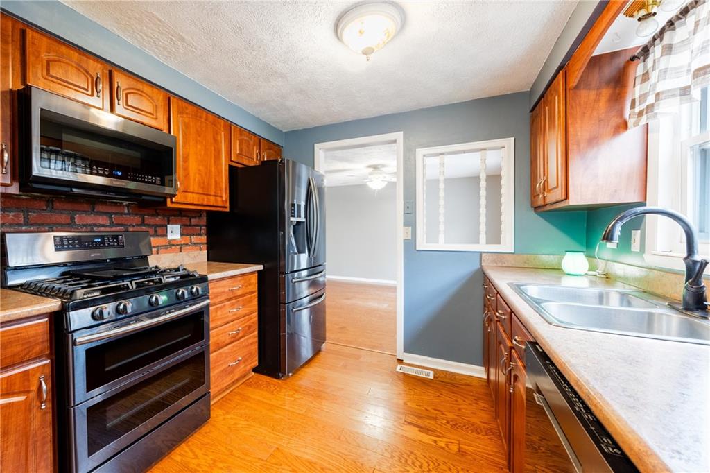 1069 Highfield Road Bethel Park, PA 15102 - Photo 13 of 41 a kitchen with stainless steel appliances granite countertop a stove a sink and a microwave