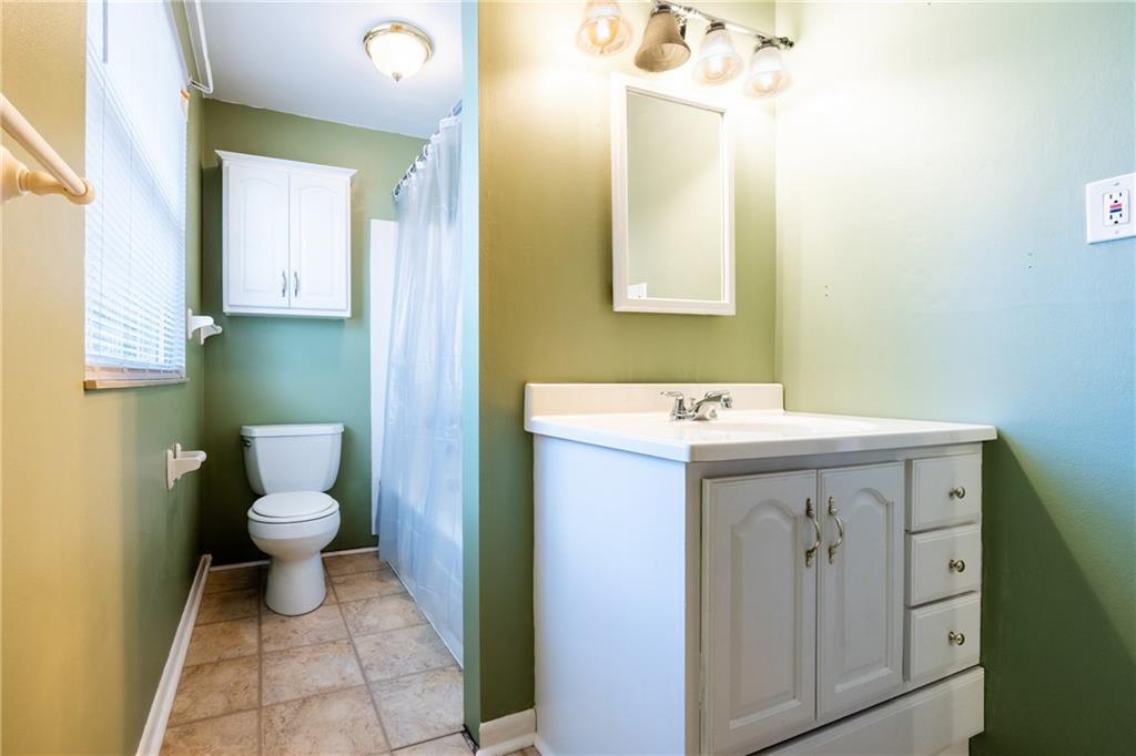 1069 Highfield Road Bethel Park, PA 15102 - Photo 28 of 41 a bathroom with a sink mirror and a toilet