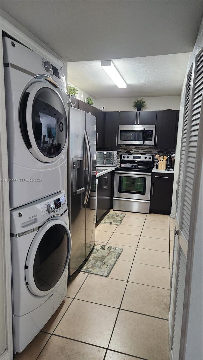 8254 Southwest 147th Place Miami, FL 33193 - Photo 8 of 14 a kitchen with a stove a washer and dryer