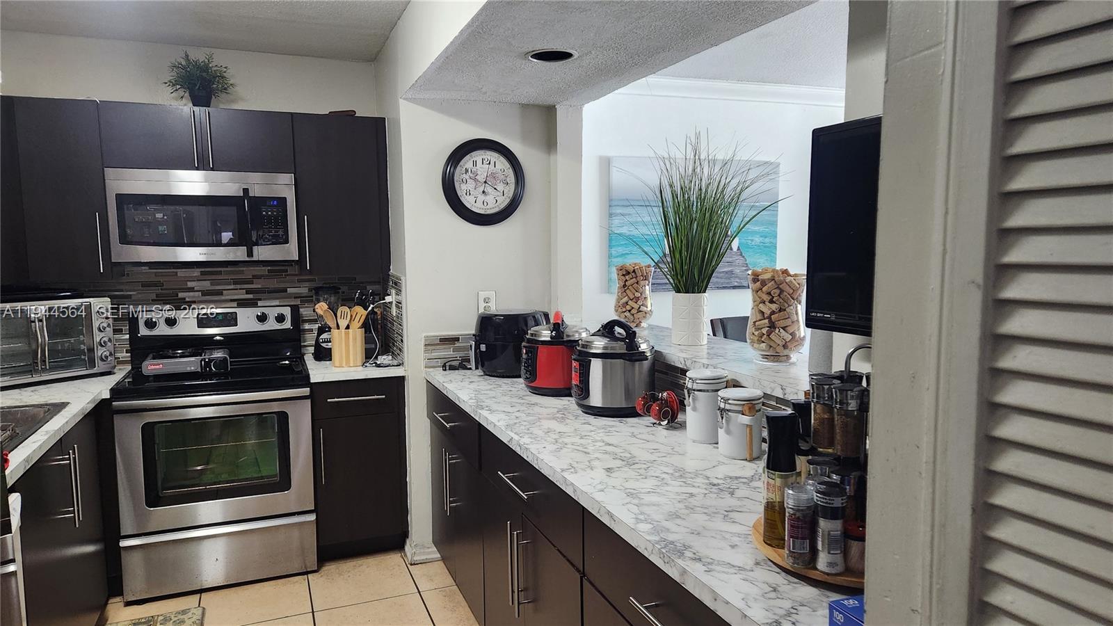 8254 Southwest 147th Place Miami, FL 33193 - Photo 9 of 14 a kitchen with stainless steel appliances granite countertop a stove and a microwave